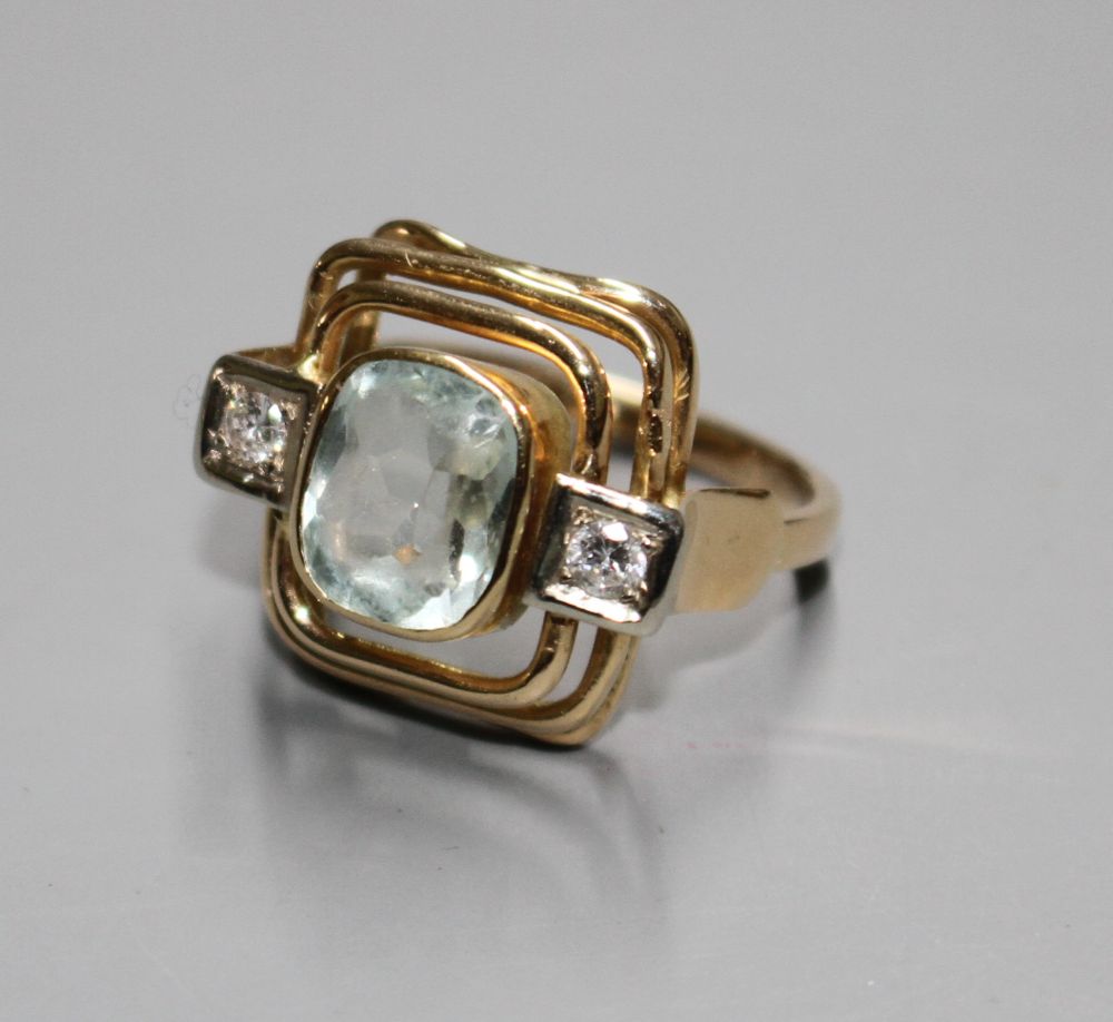 A 585 yellow metal, aquamarine and diamond set three stone dress ring, with pierced stepped setting,